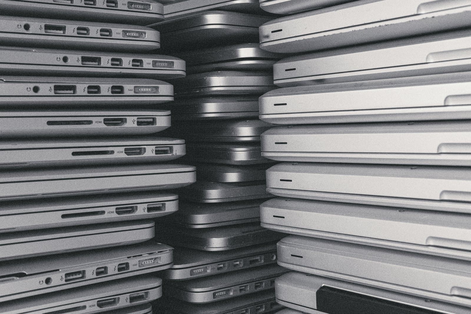 Rows of closed laptops stacked in columns across a room