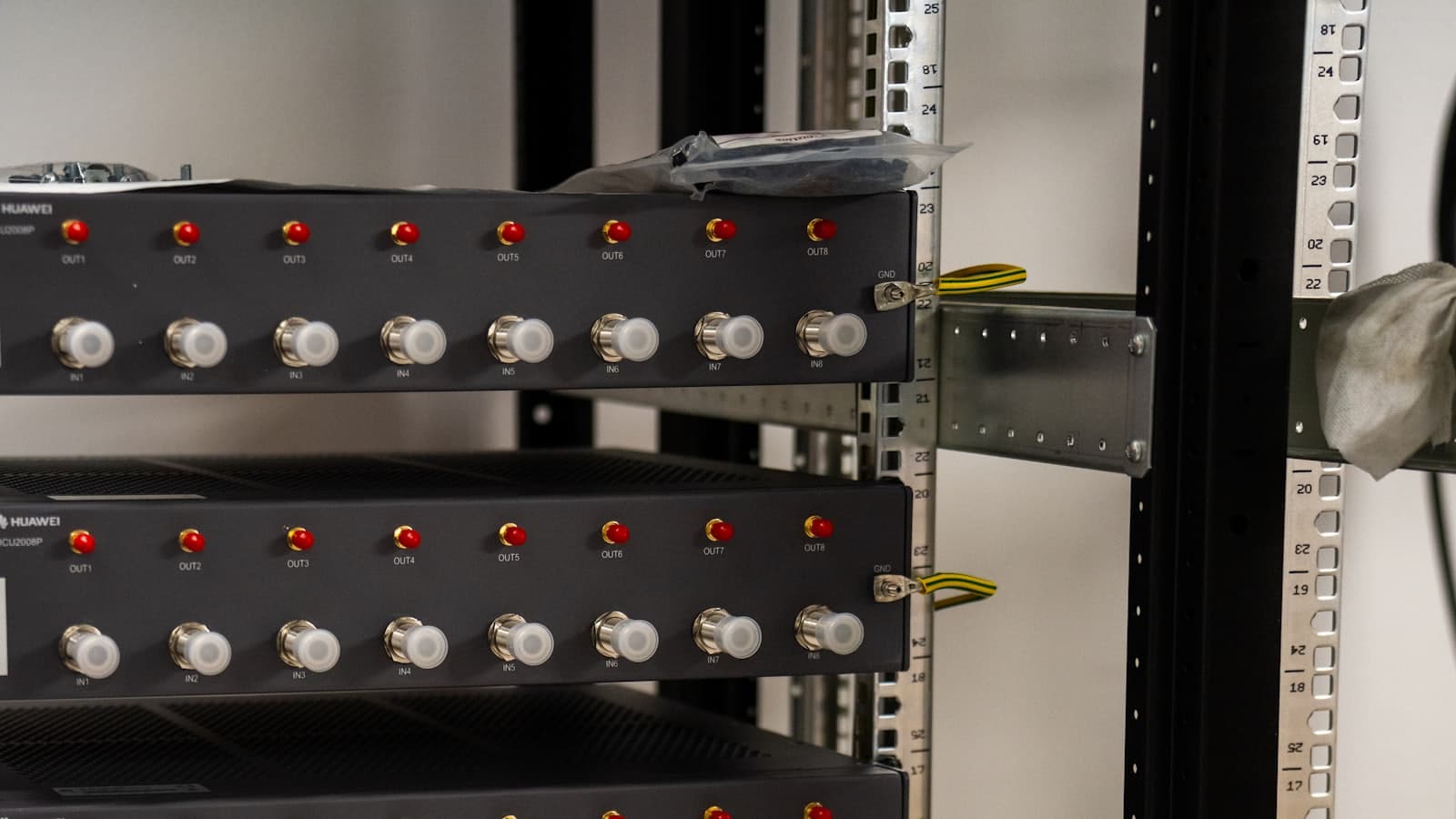 A tall server rack in a dark room, indicator lights running down its face